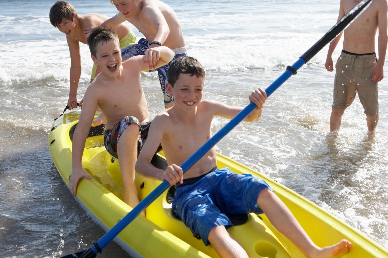 Kids playing on kayak during summer.